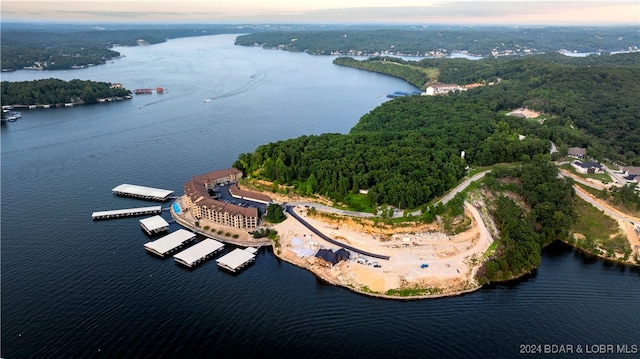 aerial view at dusk featuring a water view