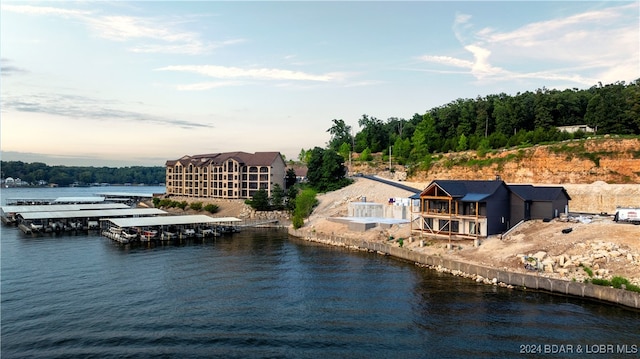 aerial view at dusk featuring a water view