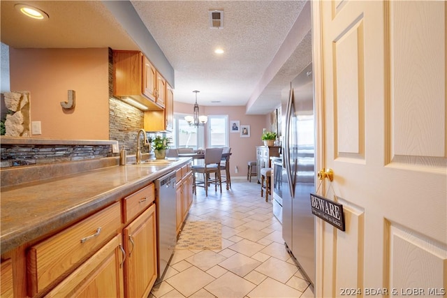33 Crow Ct Unit 1D, Lake Ozark, MO 65049 - kitchen with a sink, appliances with stainless steel finishes, a textured ceiling, decorative light fixtures, and backsplash