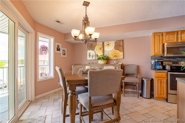 33 Crow Ct Unit 1D, Lake Ozark, MO 65049 - dining room with stone tile flooring, a chandelier, baseboards, and a textured ceiling