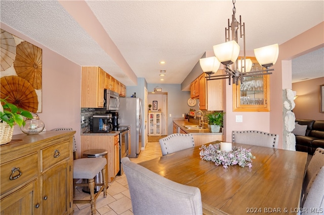 tiled dining area with a textured ceiling and sink