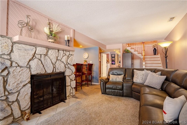 33 Crow Ct Unit 1D, Lake Ozark, MO 65049 - living room with stairs, a textured ceiling, a stone fireplace, and tile patterned floors