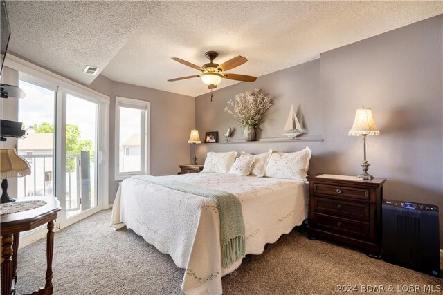 carpeted bedroom with a textured ceiling, access to outside, and ceiling fan