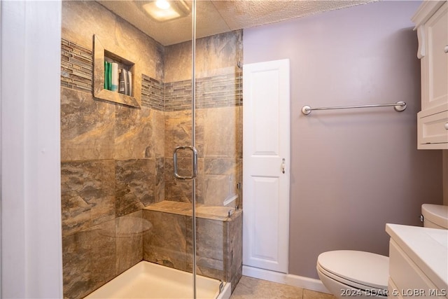 bathroom featuring vanity, a shower with shower door, a textured ceiling, and toilet