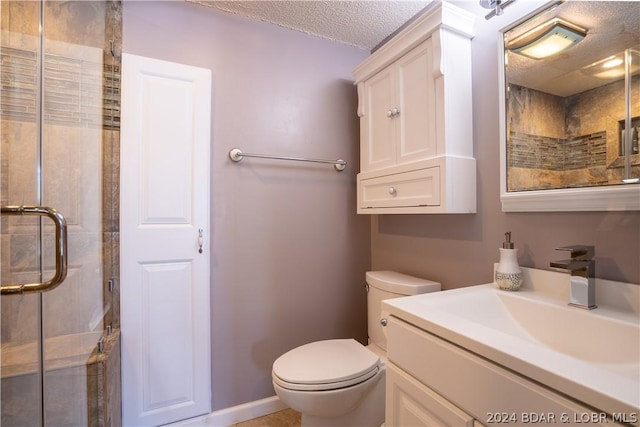 bathroom featuring toilet, a stall shower, a textured ceiling, baseboards, and vanity