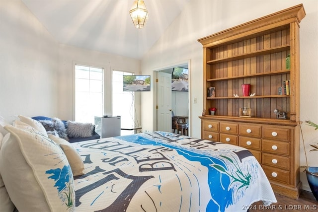 bedroom with vaulted ceiling and hardwood / wood-style flooring