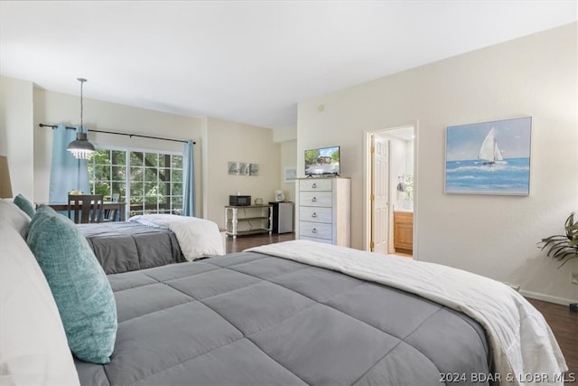 bedroom featuring dark wood-type flooring and ensuite bathroom