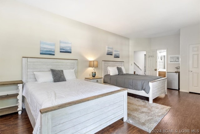 bedroom featuring connected bathroom and dark hardwood / wood-style floors