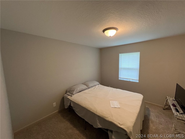 carpeted bedroom featuring a textured ceiling