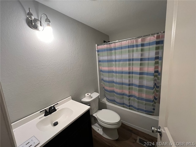 full bathroom featuring vanity, toilet, a textured ceiling, and shower / tub combo