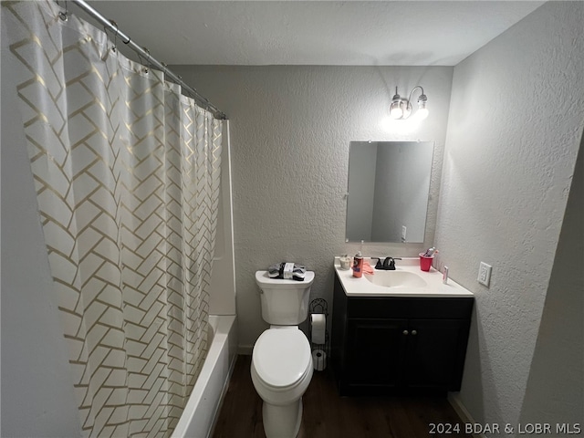 full bathroom with hardwood / wood-style floors, shower / bath combination with curtain, vanity, and toilet