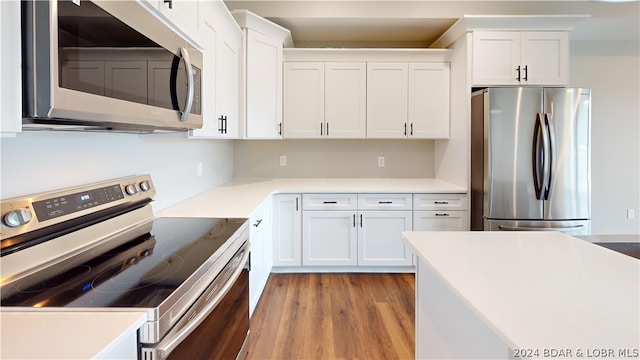 kitchen featuring appliances with stainless steel finishes, light hardwood / wood-style flooring, and white cabinetry