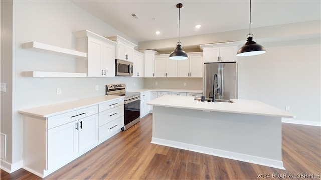 kitchen with hanging light fixtures, an island with sink, white cabinetry, appliances with stainless steel finishes, and sink