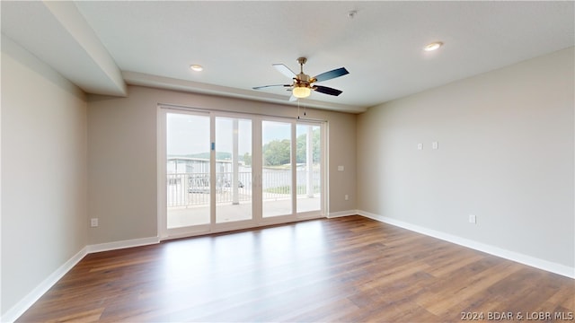 empty room with ceiling fan and hardwood / wood-style floors