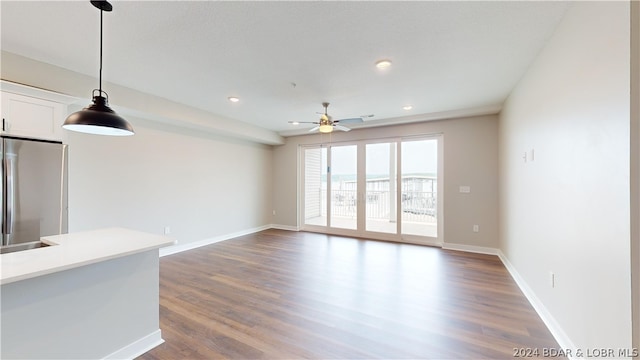 unfurnished living room with ceiling fan and dark hardwood / wood-style flooring