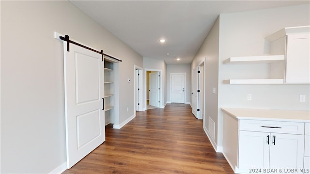 hallway featuring a barn door and dark hardwood / wood-style flooring