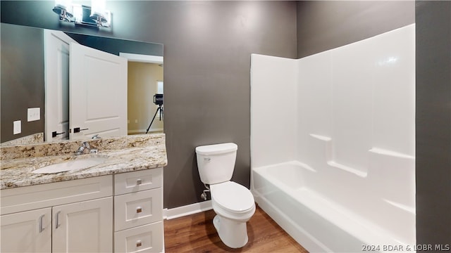 full bathroom with toilet, shower / bathing tub combination, hardwood / wood-style floors, and vanity