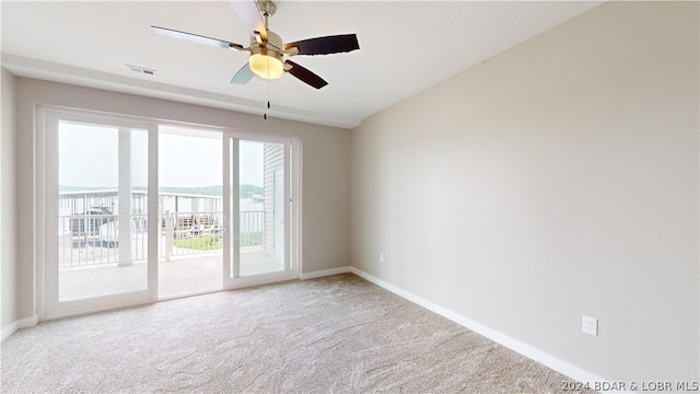 carpeted empty room featuring ceiling fan and a mountain view