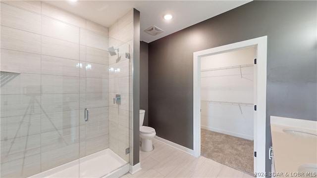 bathroom with toilet and an enclosed shower