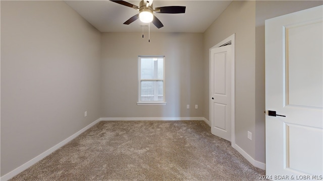 empty room with ceiling fan and light carpet