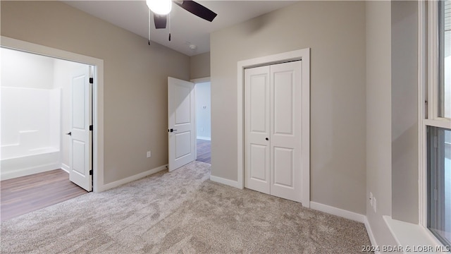 unfurnished bedroom featuring a closet, light carpet, and ceiling fan