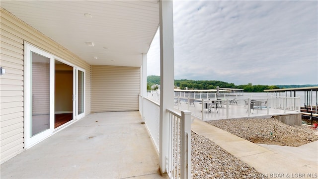 balcony featuring a patio area and a water view