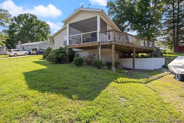 back of property with a deck, a sunroom, and a lawn