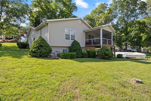 view of home's exterior featuring a sunroom and a lawn