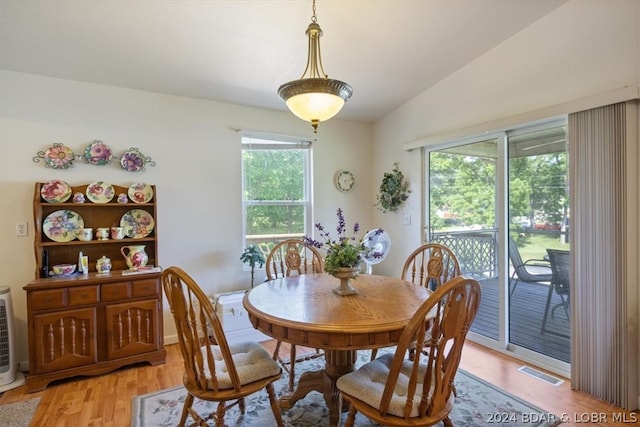 dining room with light hardwood / wood-style flooring and vaulted ceiling