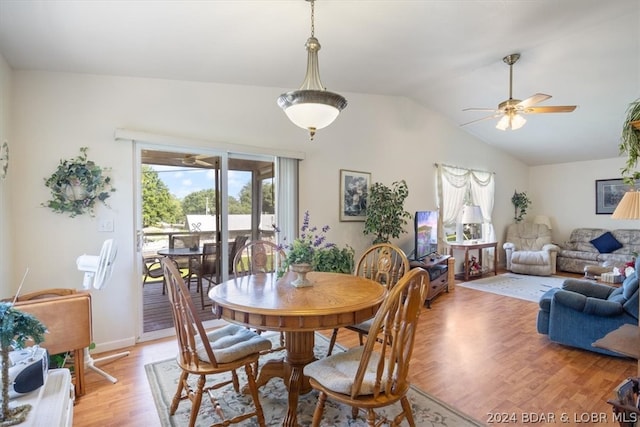 dining area with ceiling fan, vaulted ceiling, and light wood-type flooring