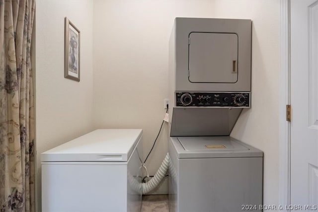 laundry area featuring tile floors and stacked washer / drying machine