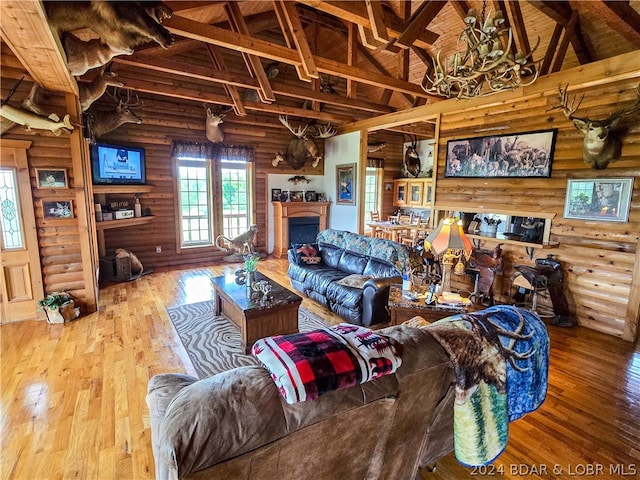 living room with beam ceiling, hardwood / wood-style flooring, high vaulted ceiling, and log walls