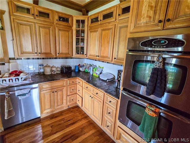 kitchen featuring backsplash, stainless steel appliances, dark hardwood / wood-style floors, and dark stone countertops