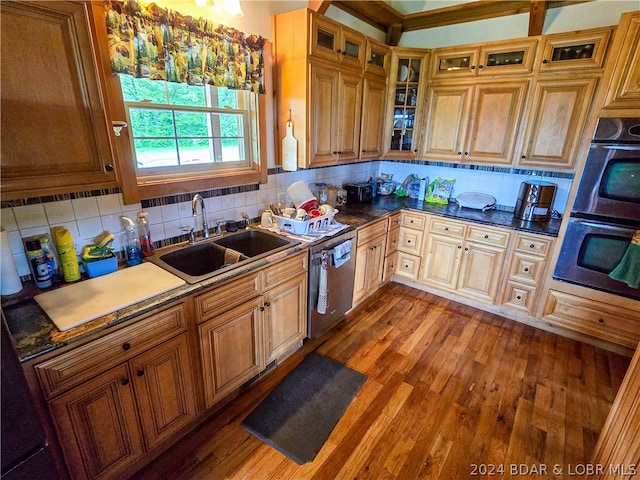 kitchen featuring hardwood / wood-style flooring, stainless steel appliances, decorative backsplash, and sink