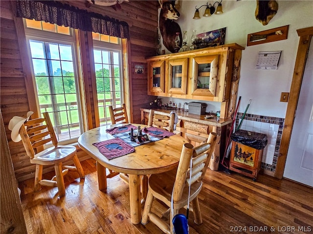 dining space featuring hardwood / wood-style flooring and wood walls