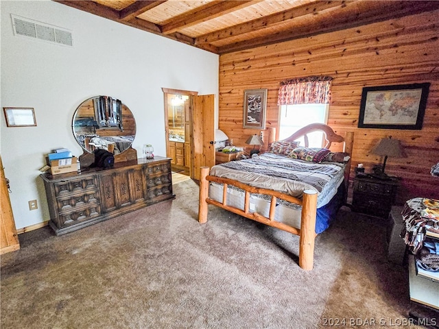 carpeted bedroom with wood ceiling, beam ceiling, wooden walls, and ensuite bathroom