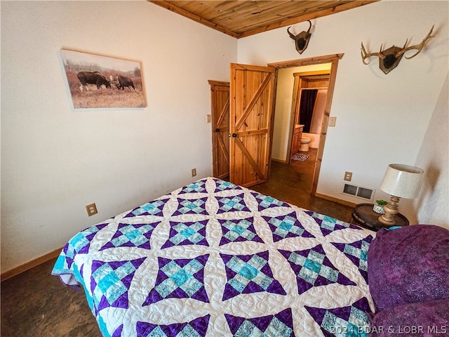 bedroom with ensuite bath and wood ceiling