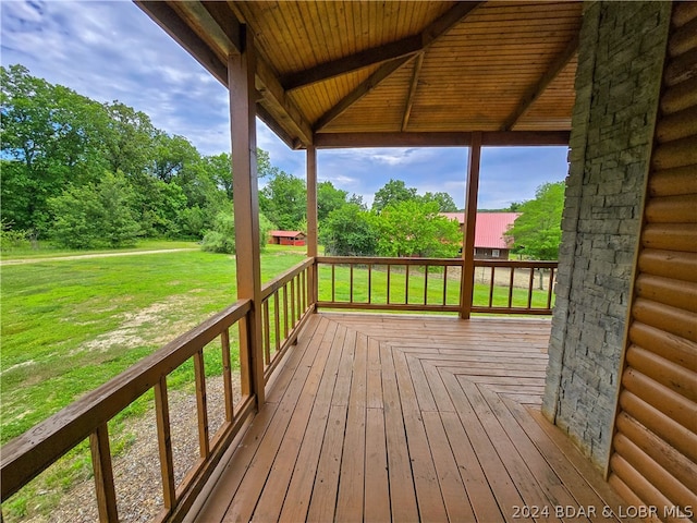 wooden terrace featuring a lawn