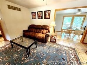 tiled living room with ceiling fan