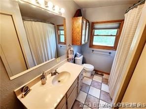 bathroom featuring tile patterned flooring, vanity, and toilet