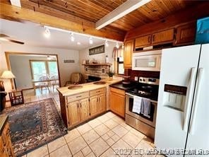 kitchen with beamed ceiling, kitchen peninsula, white appliances, light tile patterned flooring, and wood ceiling