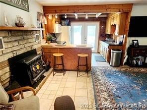 kitchen with french doors, track lighting, a kitchen breakfast bar, light tile patterned flooring, and kitchen peninsula