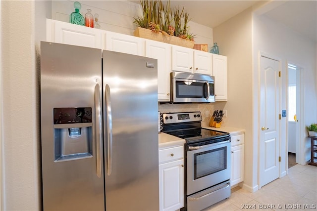 kitchen featuring light tile patterned floors, white cabinetry, appliances with stainless steel finishes, and tasteful backsplash