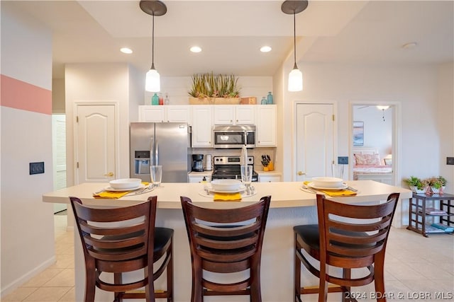 kitchen featuring white cabinetry, a spacious island, decorative light fixtures, and appliances with stainless steel finishes