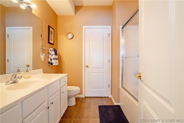 full bathroom featuring tile patterned floors, vanity, toilet, and bath / shower combo with glass door