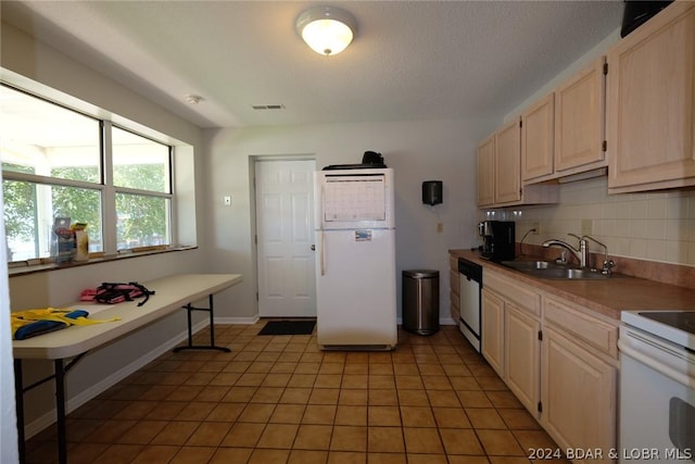kitchen featuring a sink, light brown cabinets, white appliances, backsplash, and visible vents