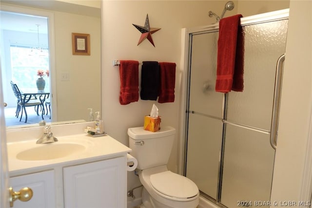 bathroom featuring vanity, an enclosed shower, and toilet