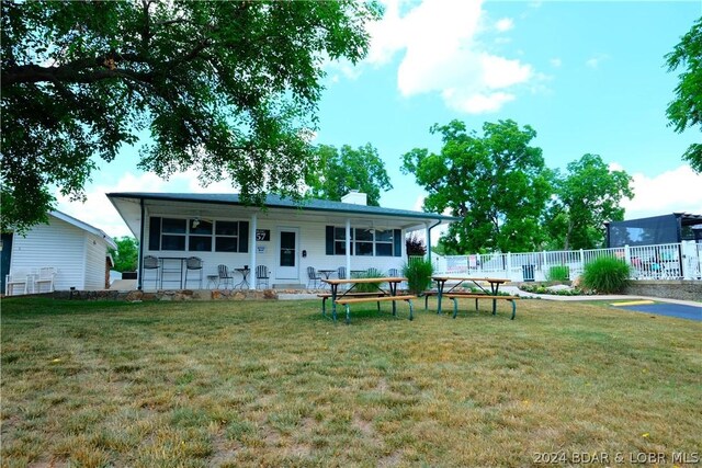 back of house with a yard, fence, and a chimney