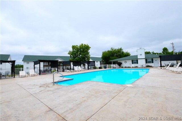 pool featuring a patio and fence