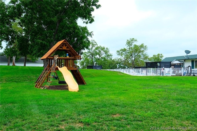 view of playground with fence and a yard